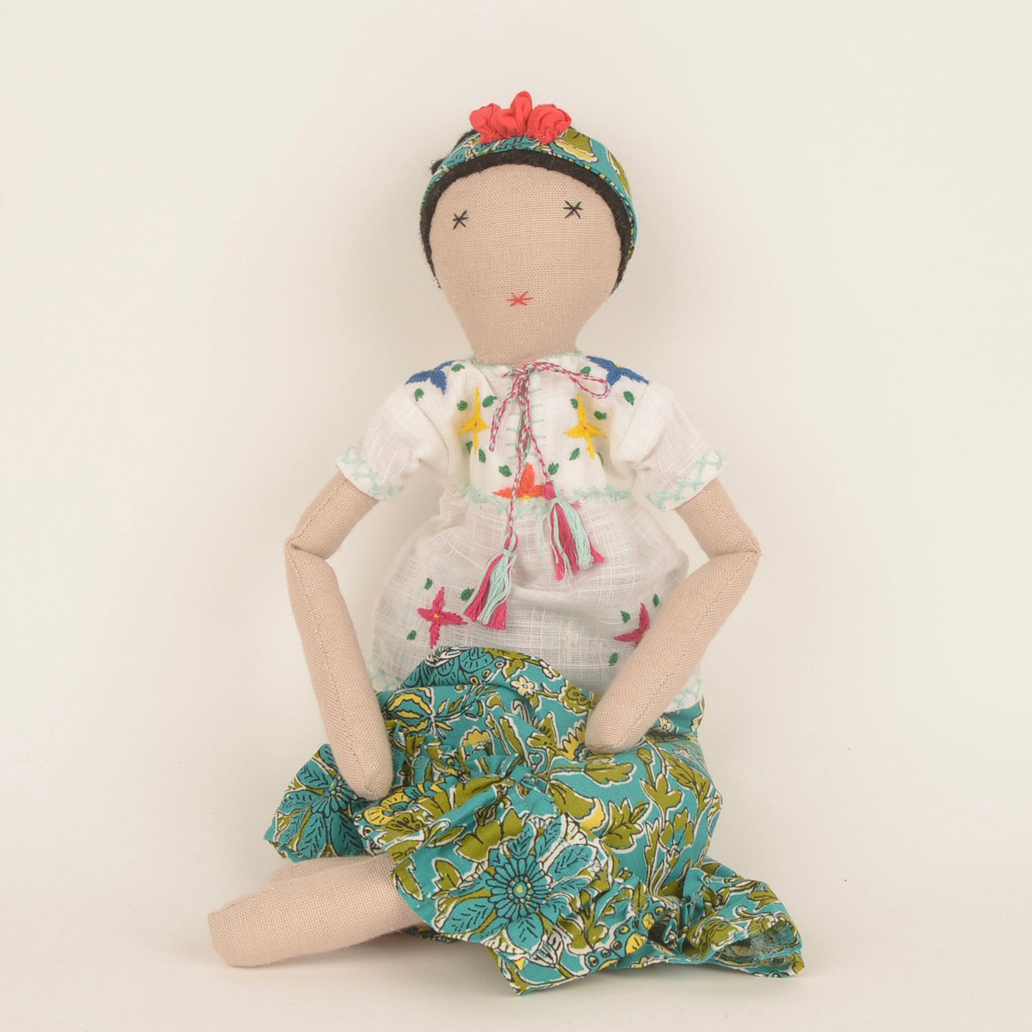 Frida, a handcrafted Afghan doll with vibrant floral patterns and intricate embroidery, symbolizing resilience and empowerment.